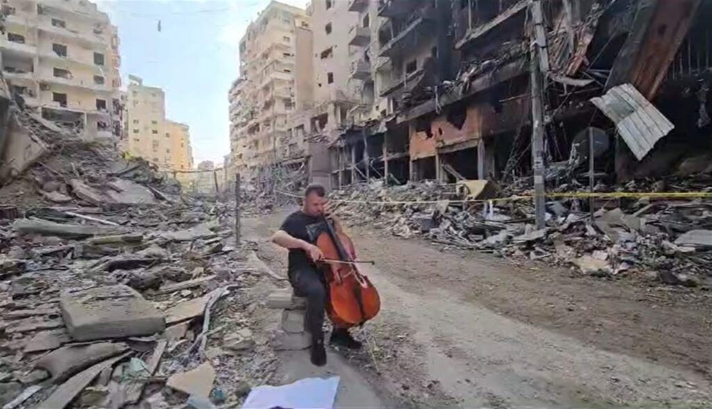بالفيديو.. يعزف وسط دمار الضاحية