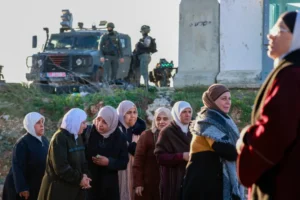 فلسطينيات عند معبر قلنديا شمال القدس المحتلة بانتظار السماح لهم بالوصول إلى المسجد الأقصى (الفرنسية)